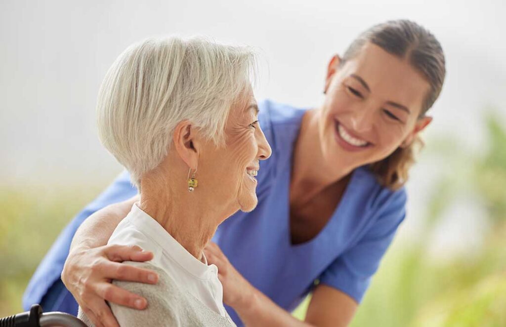 A social worker sits with an older adult and an adult family member, listening and providing guidance in a comfortable lounge.